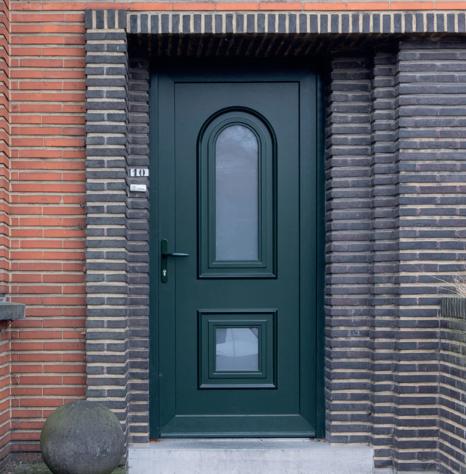 Groene klassieke voordeur met boograam